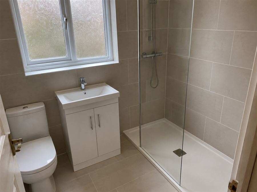 Bathroom after renovation — new shower enclosure, vanity and tiling