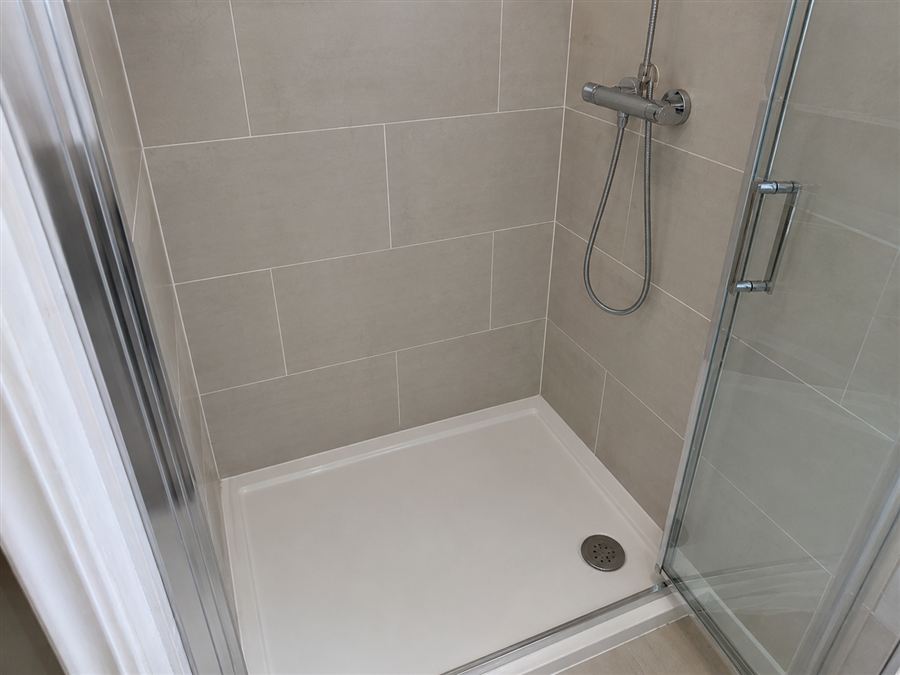 Shower area after the work — new tray, screen and tiling